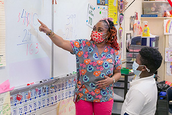 teacher helping student at whiteboard North Shore